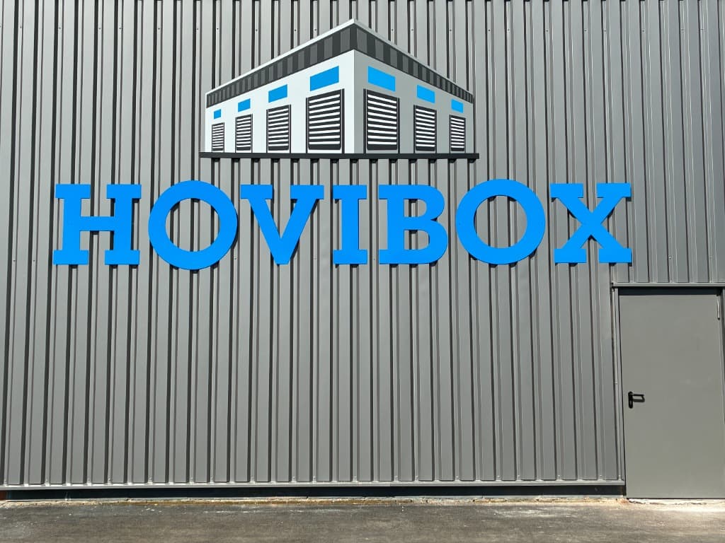Buitenzicht van de opslagfaciliteit met het blauwe Hovibox logo op de gevel